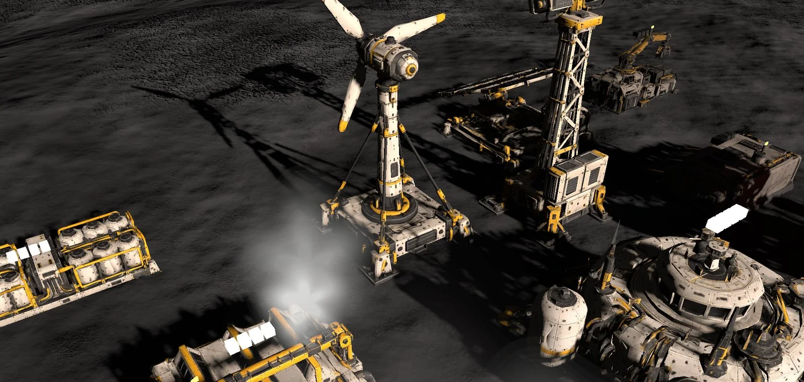 In-game screenshot: a mining operation on dark rock. An off-white wind turbine with yellow-striped blades, a lattice drill rig, cargo modules and the domed command hub, venting steam.